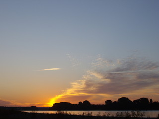 Sonnenaufgang / Sonneuntergang über dem Fluss (Rhein)