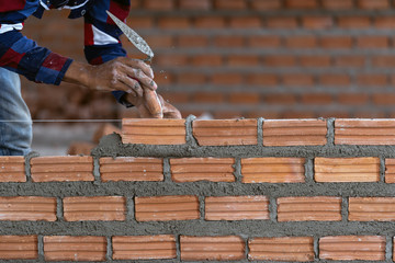 Closeup hand professional construction worker laying bricks in new industrial site. construct industry and masonry concept