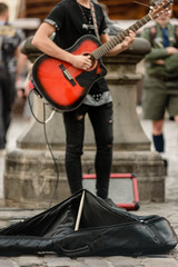 Fototapeta na wymiar Street musician playing guitar for tourists on city center