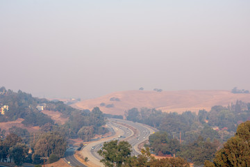 Fototapeta na wymiar Aeril bird's eye view of light morning traffic on California highway 280 with grey haze from wild forest fire