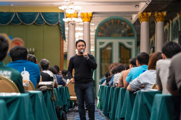 Asian Speaker with casual suit standing and giving the knowledge with audience in the conference hall or seminar meeting, business and education concept