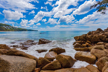 white bubbles from big waves hit on the rock at the end of Naithon beach Phuket