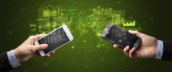 Close up of two hands holding smartphones to sync business data