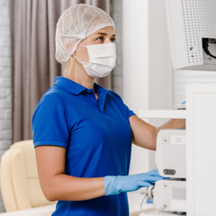 Fototapeta na wymiar Female doctor in uniform using ultrasonic machine in hospital