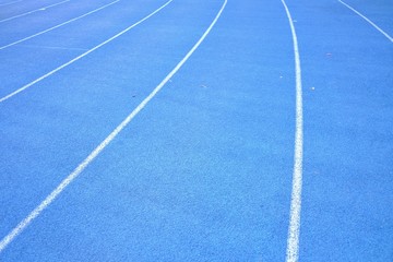 Close up blue running lane with a white curve for background texture 