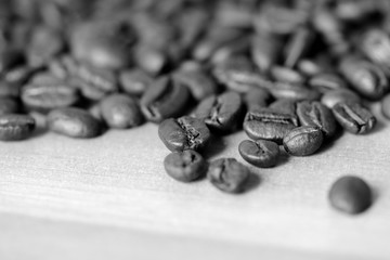 Roasted coffee beans on a wooden background. Black and white