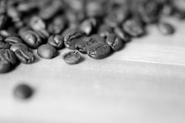 Roasted coffee beans on a wooden background. Black and white