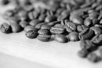 Roasted coffee beans on a wooden background. Black and white