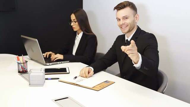 4K.Young handsome man smiles and shows  thumb up to  camera in office work area