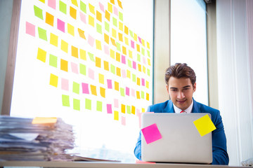 Young handsome employee with many conflicting priorities   
