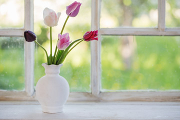 Obraz na płótnie Canvas tulips in vase on old windowsill