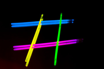 Colorful fluorescent light neon big glow stick on mirror reflection black background
