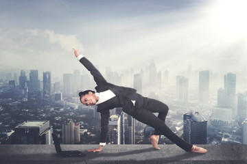 Businesswoman dances with a laptop on the rooftop
