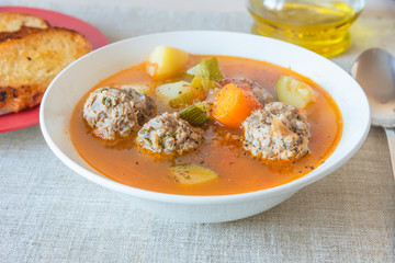 Mexican vegetable soup with meatballs Albondigas in a plate close-up.