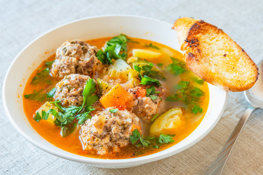 Mexican soup with meatballs and vegetables in a plate on a rustic background - Albondigas