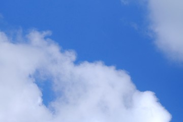 White fluffy clouds against blue sky in bright day for background texture