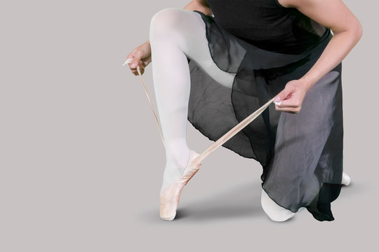 Female dancer ties up her ballet shoes - Powered by Adobe