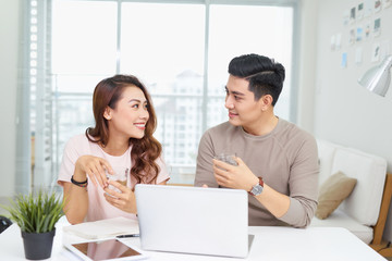 Businessman and businesswoman working with laptop at modern office