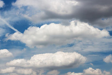 Blue sky with fluffy clouds; soft cumulus clouds on blue sky. Skyscraper background