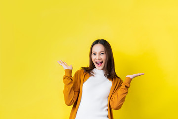 Asian girl is surprised she is excited.Yellow background studio