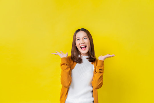 Asian Girl Is Surprised She Is Excited.Yellow Background Studio