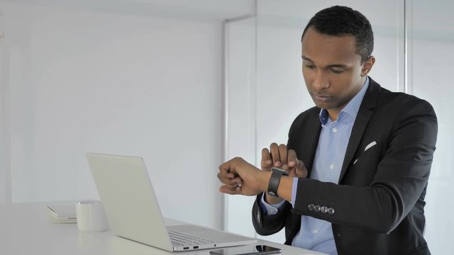 Casual Afro-American Businessman Using Smartwatch for Checking Notifications