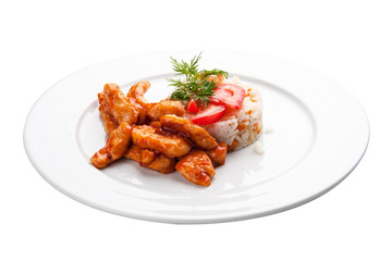 Chicken fillet in sweet and sour sauce with rice and vegetables. On a white background