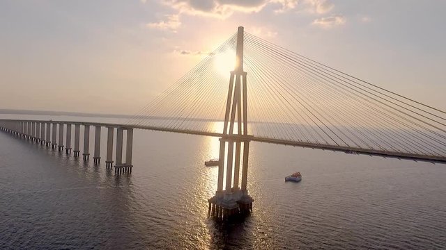 Cable-stayed bridge over the Rio Negro, in Manaus, the largest city in the middle of the Amazon Forest. Filmed by drone, with a beautiful golden sunset in the background. 10/11