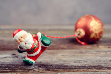 Naklejka premium little Santa Claus pulling glitter ball