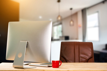 workspace with computer, laptop, office supplies, and coffee cup, smartphone, and tablet at office. desk work concept. in morning light