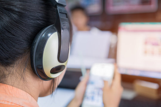 Student online testing exercise concept : Asian girl students learning on smartphone and computer pc for watching video tutorial with headphones in e-school classroom at information center