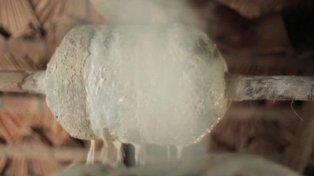 Rubber tapper adds latex to the artisanal rubber production process. The white liquid of the rubber tree is tanned over a fire to turn into rubber and be sold in the nearest city.