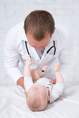 male doctor pediatrician examining little baby patient