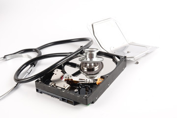 RECOVERY AND REPAIR TECHNOLOGY CONCEPT: Hard Disk Drive (HDD) with stethoscope isolated on white.