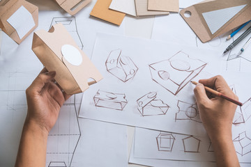 Designer sketching drawing design Brown craft cardboard paper product eco packaging mockup box...