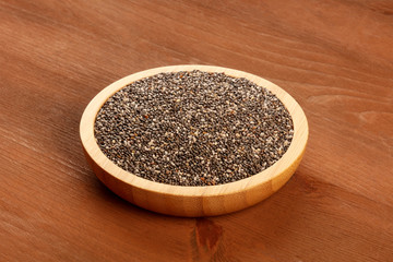 A photo of chia seeds on a dark rustic wooden background with copy space