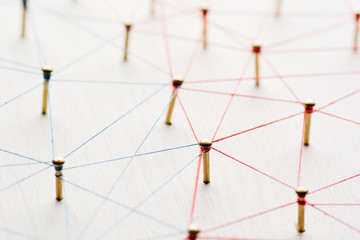 Linking entities. Network, networking, social media, internet communication abstract. A small network connected to a larger network. Web of gold wires on white wooden background. Network hub or key