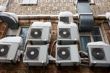 The air conditioning system surrounded by snow and ice, close-up, as a symbol of powerful cooling. The air conditioning systems. Winter cooling - with ice and snow.