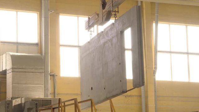 Bridge single girder crane moves the finished wall panel. Production of wall panels for frame housing construction.