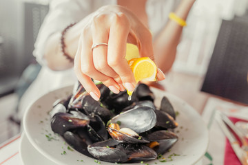 Young Woman Eating Freshly cooked Mussels