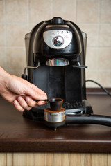 Photo of coffee maker, human hand pouring coffee into mug