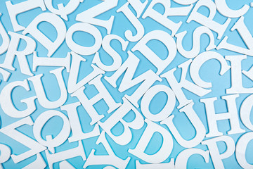  White wooden alphabet letters top view on blue background