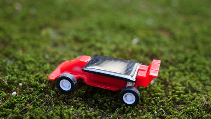 Fototapeta na wymiar Car toy on the dry green Moss