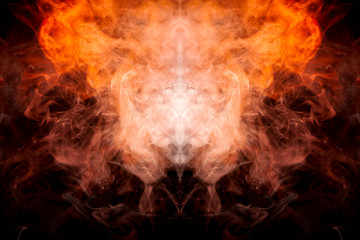 Fototapeta premium A background of orange and yellow wavy smoke in the shape of a ghost's head or a man of mystical appearance on a black isolated ground. Bright abstract pattern of steam from vape.
