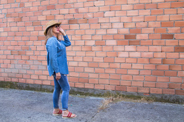 portrait of senior woman with sunglasses and straw hat in jeans