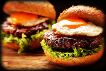 Hamburger with beef meat and fresh vegetables on wooden background