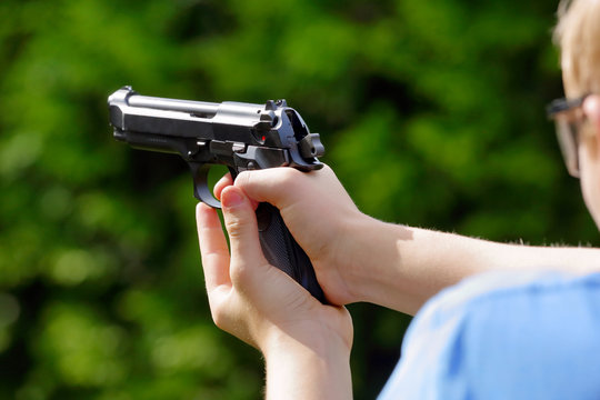 Young boy practice shooting guns on outdoor