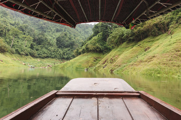 Wide angle shot of wooden boat against scenic mountain background. Relaxation and travel concept.
