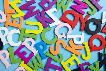 Multi colored alphabet on blue background. Abstract backdrop.