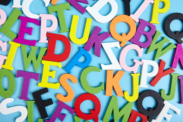 Multi colored alphabet on blue background. Abstract backdrop.